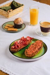 Spanish breakfast, two sandwiches with grated tomato and salted thinly sliced pork, orange juice, coffee with condensed milk and a muffin. Table setting. Breakfasts of the peoples of the world. 