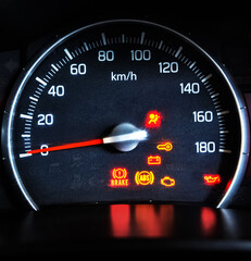 Car Speedometer with Red Needle on zero and sign lights on in the meter, background.