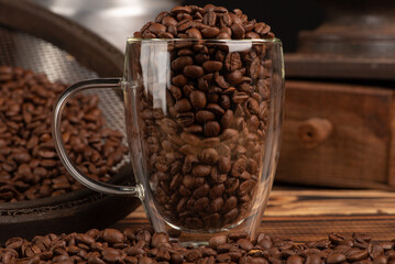Coffee, glass coffee cup full of coffee beans, dark background, selective focus.