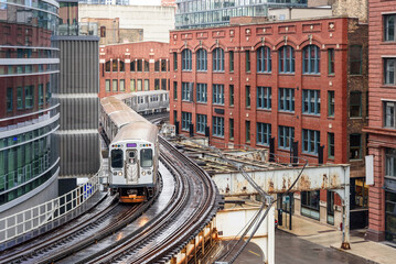 Commuter train on winding elevated tracks in downtown Chicago on a rainy spring day