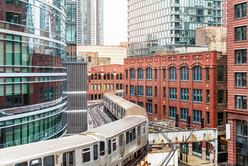 Eelvated train running between both old and modern buildings in downtown Chicago