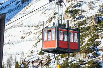 Aerial tramway passenger cabin arriving at the lower station in a ski resort in the European Alps on a sunny winter day