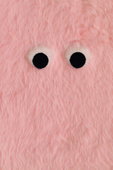 Cute fluffy monster made with pastel pink faux fur. Minimal concept. Creative funny face...
