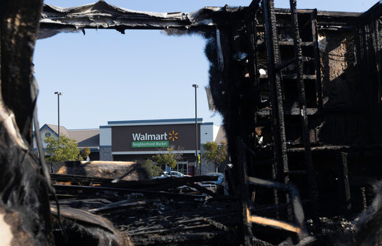A completely burned out RV motorhome trailer from a fire or explosion in a California Walmart shopping center parking lot.