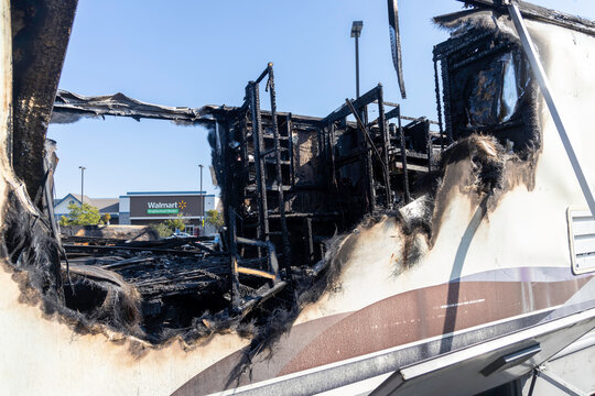 A completely burned out RV motorhome trailer from a fire or explosion in a California Walmart shopping center parking lot.