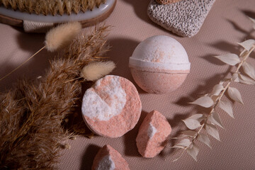 facilities for spa treatments. Masage brush, leg pumice, bathroom bombs on a peach background. Top...