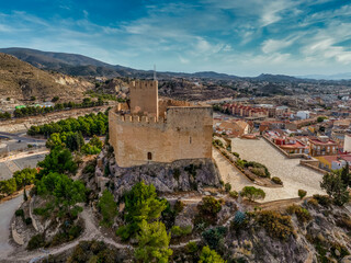Fototapeta na wymiar Aerial view of Petrer, medieval town and hilltop castle with restored tower and battlements near Elda Spain,