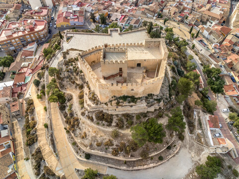 Aerial view of Petrer, medieval town and hilltop castle with restored tower and battlements near Elda Spain,