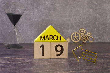 Vintage photo, March 19th. Date of 19 March on wooden cube calendar, copy space for text on board