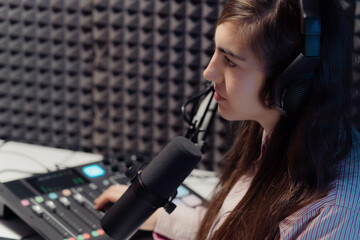 Young woman in a striped shirt focused on audio mixing in a studio, embodying the concentration...