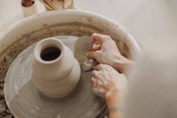 Close up of artisan's hands shaping clay bowl in pottery studio. Pottery art and creativity