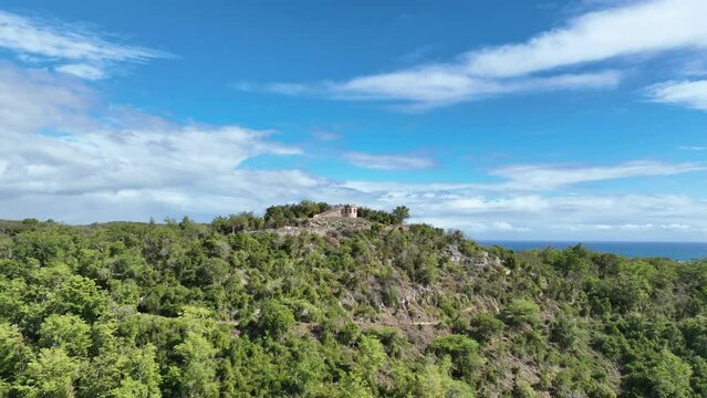 Dynamic drone video of historic Spanish military stone fortress ruins on top of a hill in southern Puerto Rico