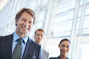 Mature businessman, portrait and pride in leadership, office and confidence in management. Business people, teamwork and collaboration or support in workplace, smiling and ceo at startup company