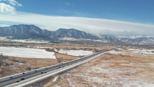 A gentle sweep capturing the charm of Boulder, Colorado, framed by the iconic Flatirons in the distance, while Highway 36 cuts through the middle, adding a dynamic element to the scene.