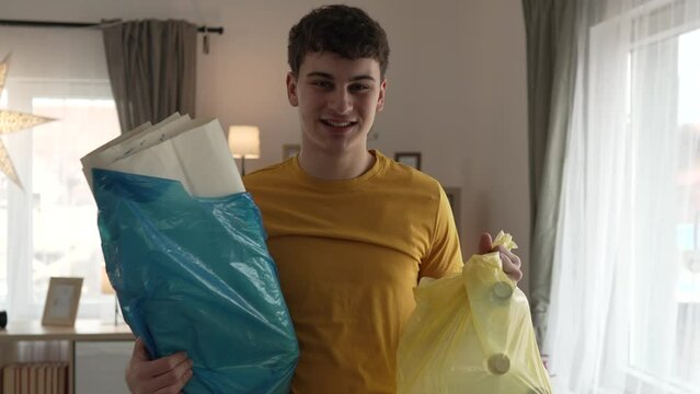 young man recycle at home sorting waste plastic paper and glass