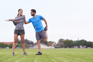 Happy couple, fitness and stretching body on green grass for outdoor workout or exercise in nature....