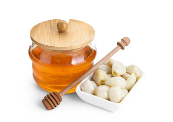 Peeled garlic cloves, jar with honey and dipper isolated on white