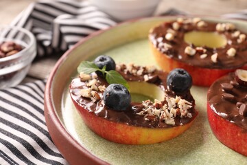 Fresh apples with nut butter, blueberries and nuts on table, closeup