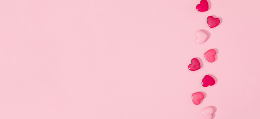 Valentine's Day background with hearts on pale pink background. Top view, flat lay