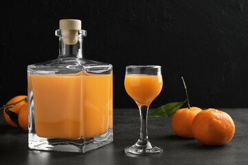 Delicious tangerine liqueur and fresh fruits on grey table