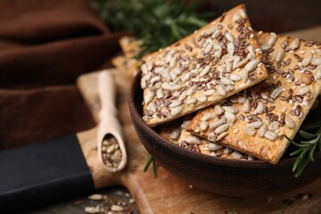 Cereal crackers with flax, sunflower, sesame seeds and rosemary on table, closeup. Space for text