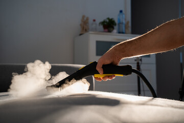 cleaning a gray sofa with steam