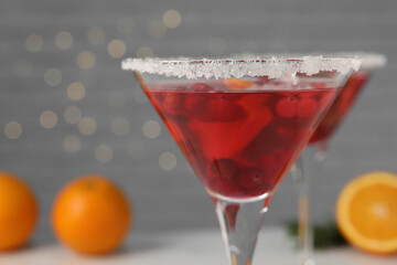 Tasty cranberry cocktail in glass on light background, closeup