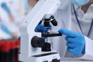 Scientist working with microscope in laboratory, closeup