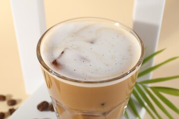 Refreshing iced coffee with milk in glass on table, closeup