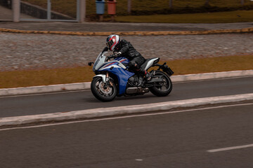 moto esportiva azul fazendo uma curva 