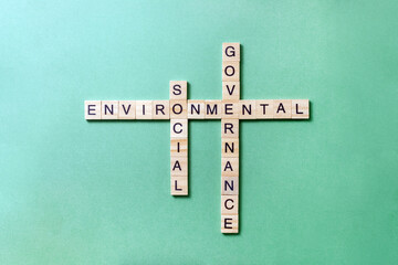 Words Environmental Social Governance made up of wooden blocks with letters on green background. Crossword ESG. World sustainable environment concept