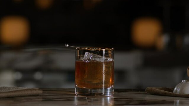 Bartender presents an old fashioned on top of the bar