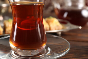 Traditional Turkish tea in glass on wooden table, closeup. Space for text
