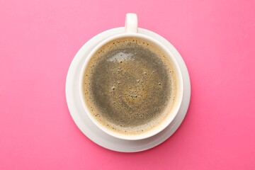 Fresh coffee in cup on pink background, top view