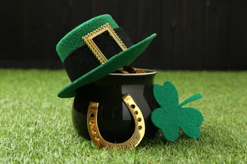 St. Patrick's day. Pot of gold with leprechaun hat, horseshoe and decorative clover leaf on green...