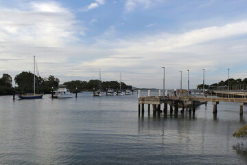 Auckland Creek with boats, pier, the ocean and clouds at sunset in Gladstone, Queensland, Australia