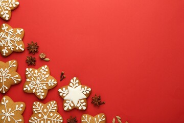 Tasty star shaped Christmas cookies with icing and spices on red background, flat lay. Space for text
