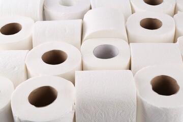Many soft toilet paper rolls as background, closeup