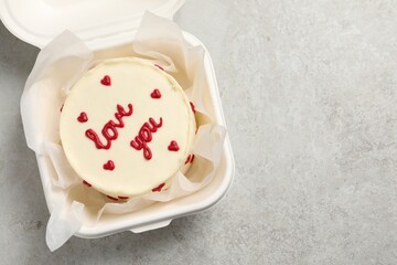 Bento cake with Love You text in takeaway box on light grey table, top view. Space for text. St. Valentine's day surprise