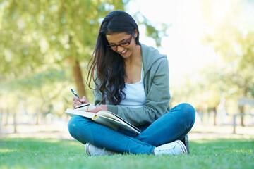 Writing, grass or happy woman in nature with notes for learning knowledge, information or education. Smile, diary journal or student in park for studying idea or peace on college campus lawn to relax