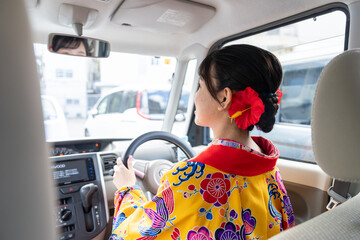 沖縄県那覇市で琉装で車を運転する２０代の若い日本人女性 A young Japanese woman in her 20s driving a car in Ryuso in Naha City, Okinawa Prefecture - obrazy, fototapety, plakaty