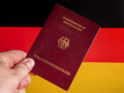 German Child's Passport Held Against Flag Background