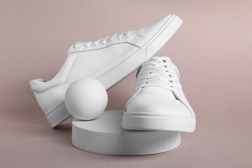 Pair of stylish white sneakers on grey background