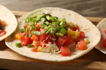 Delicious taco with vegetables, green onion, lime and ketchup on table, closeup