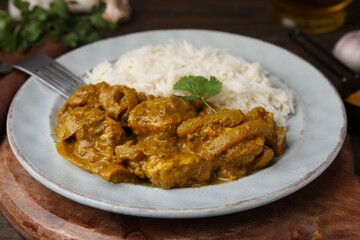Delicious chicken curry with rice on wooden table, closeup