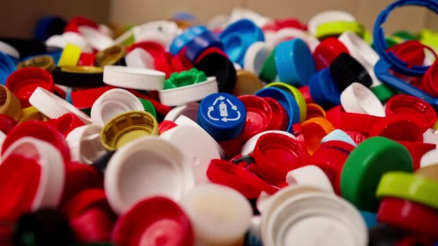Close-up of multi-colored caps from used bottles stored at recycling and waste disposal sorting station