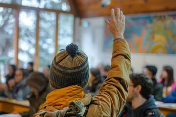A student raises a hand high in a crowded lecture hall, eager to engage and learn, embodying the spirit of academic curiosity and education.

