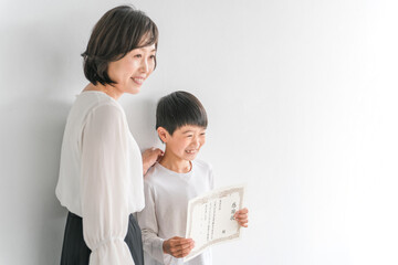 感謝状を持つ子供と女性（先生・ママ）
