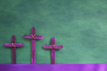 Three purple wooden cross in green background. Holy week and lent season celebration concept.