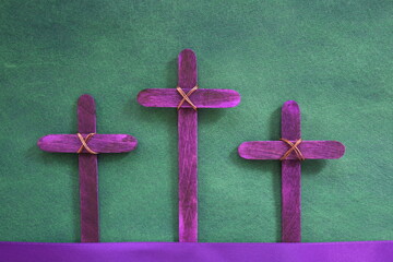 Three purple wooden cross in green background. Holy week and lent season celebration concept.